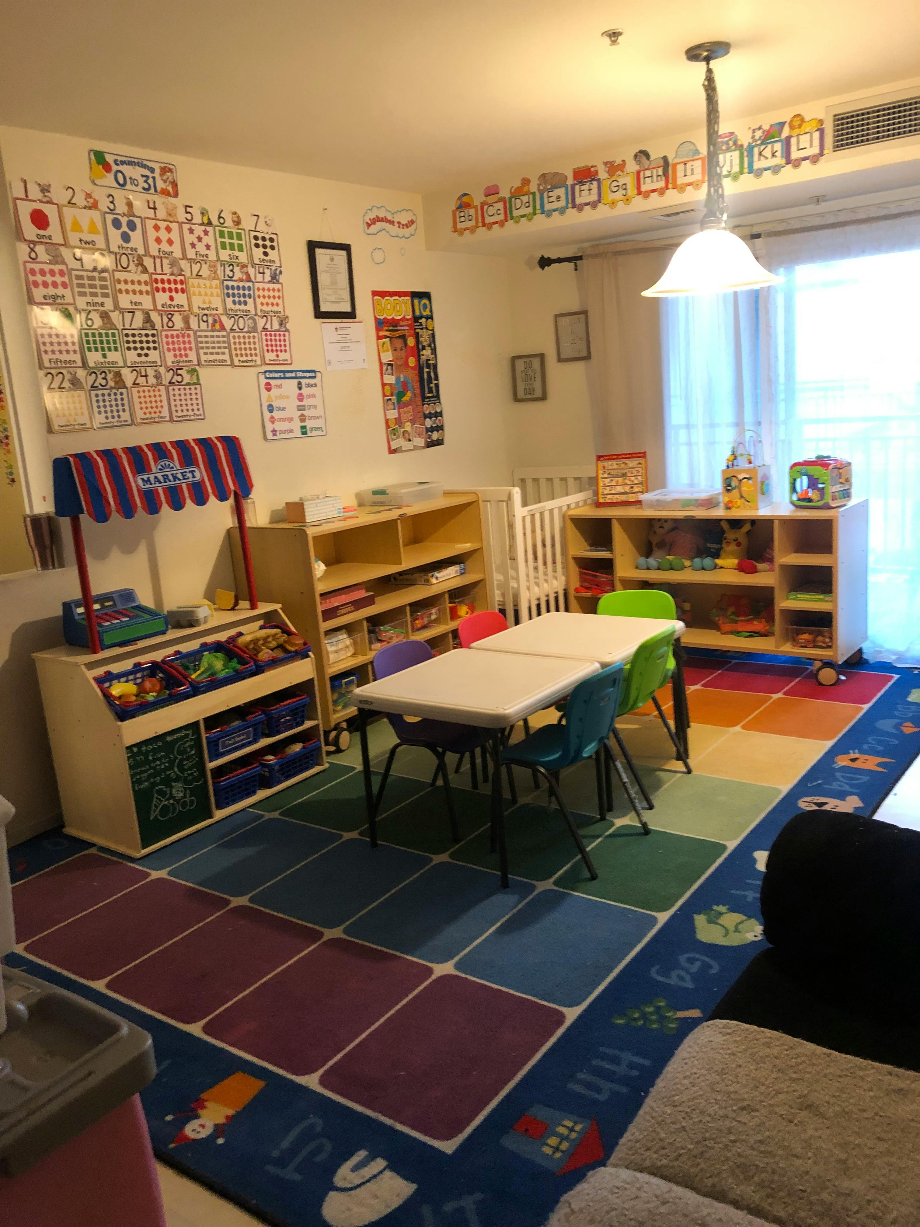 Playroom with a small table and chairs, toy shelves, and a play market stand