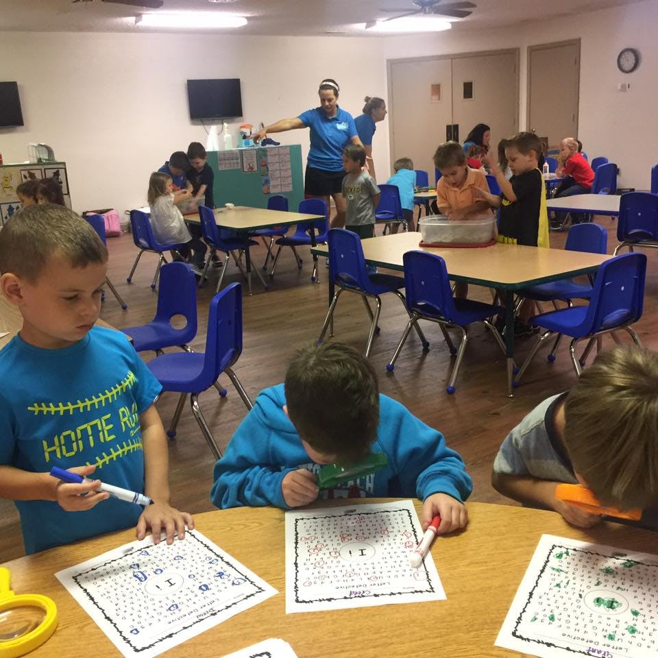 Children doing an activity at tables in a classroom