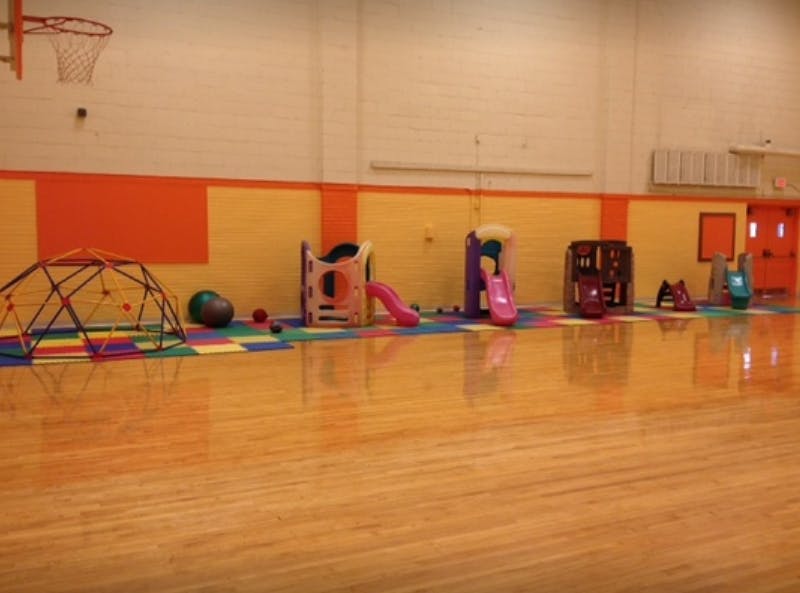 Indoor playground with slides and climbing dome on a gym floor