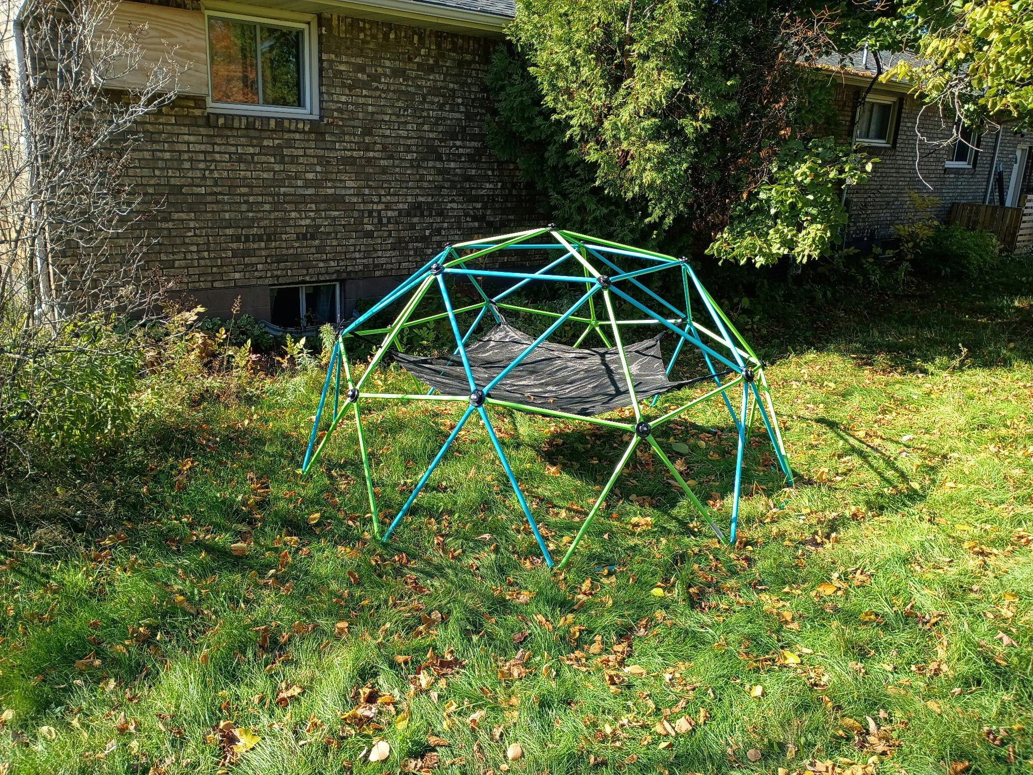 Geodesic dome climbing frame with a hammock in a backyard