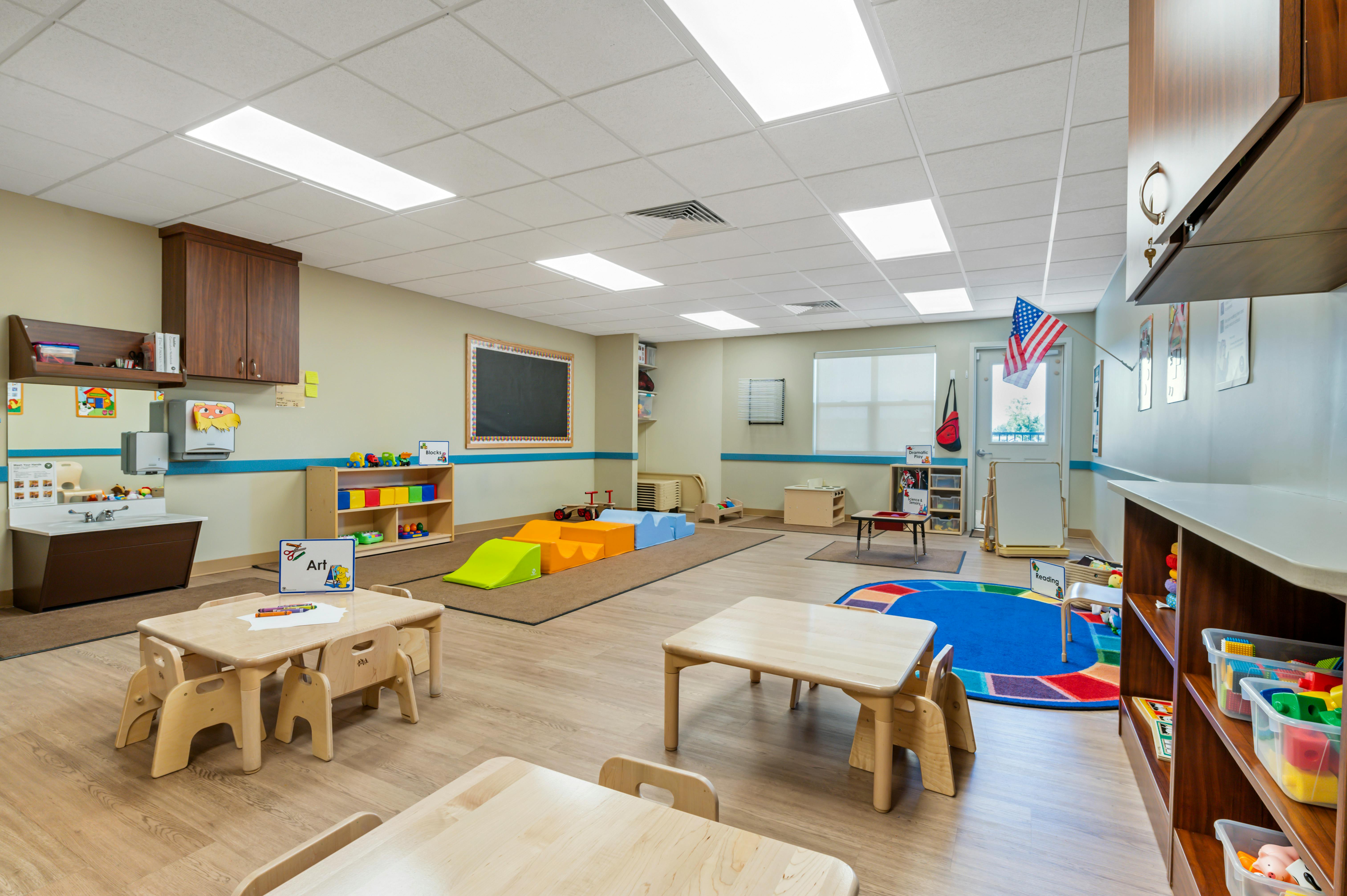 A colorful empty classroom with children's tables and chairs