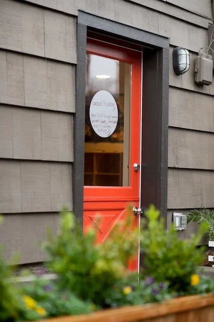 Red door with a half window and white sign that says "Good Morning"