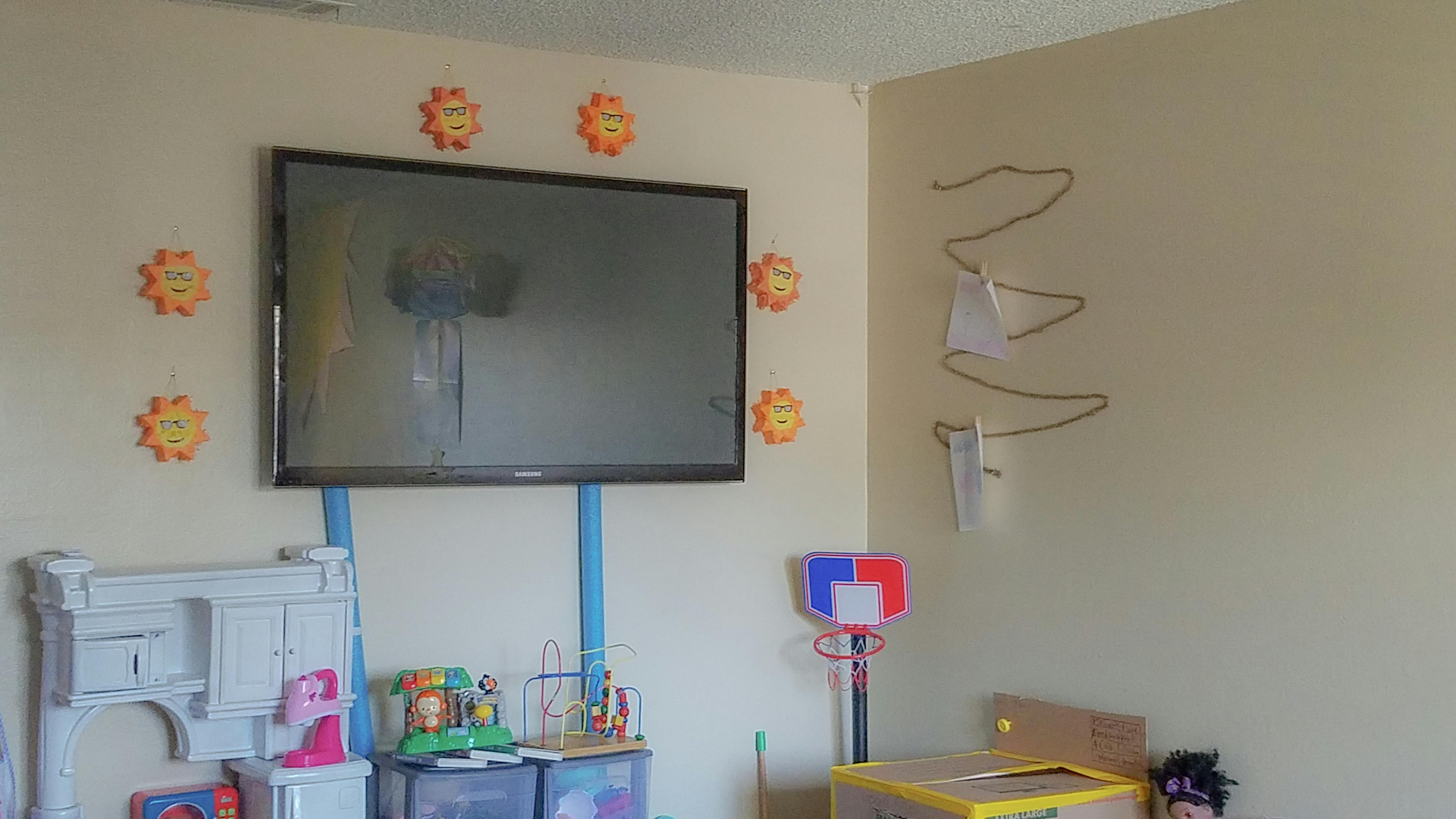 Television mounted on a wall with decorations