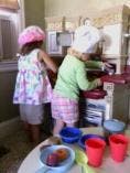 Two children playing with toy kitchen items
