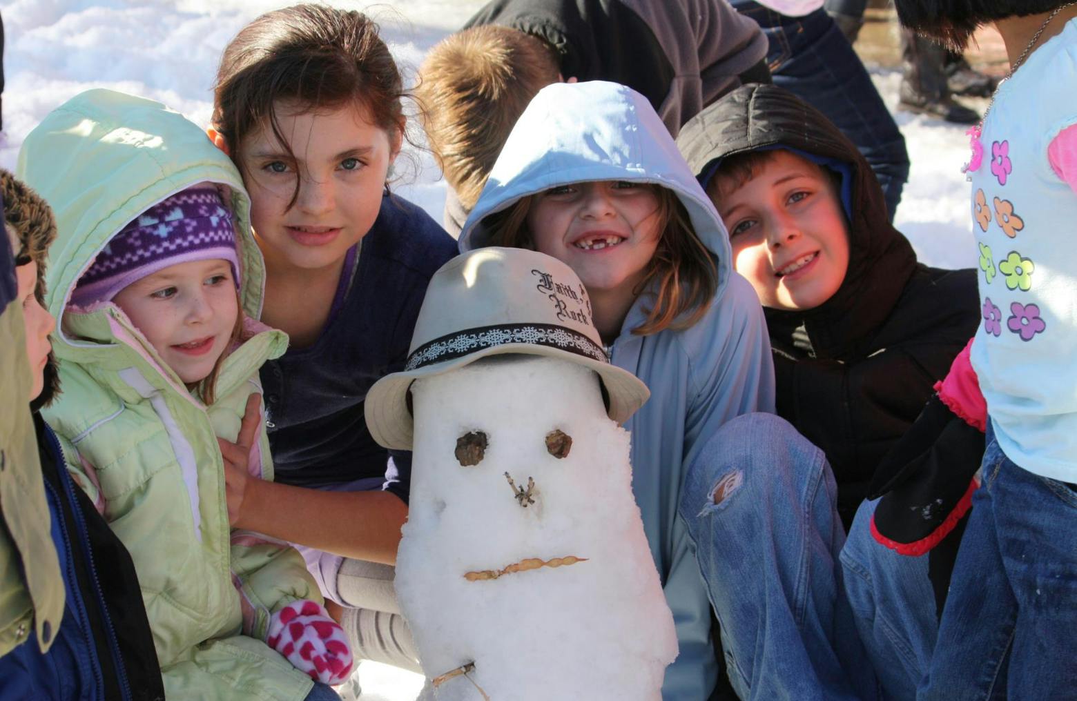 Children and a snowman with a hat