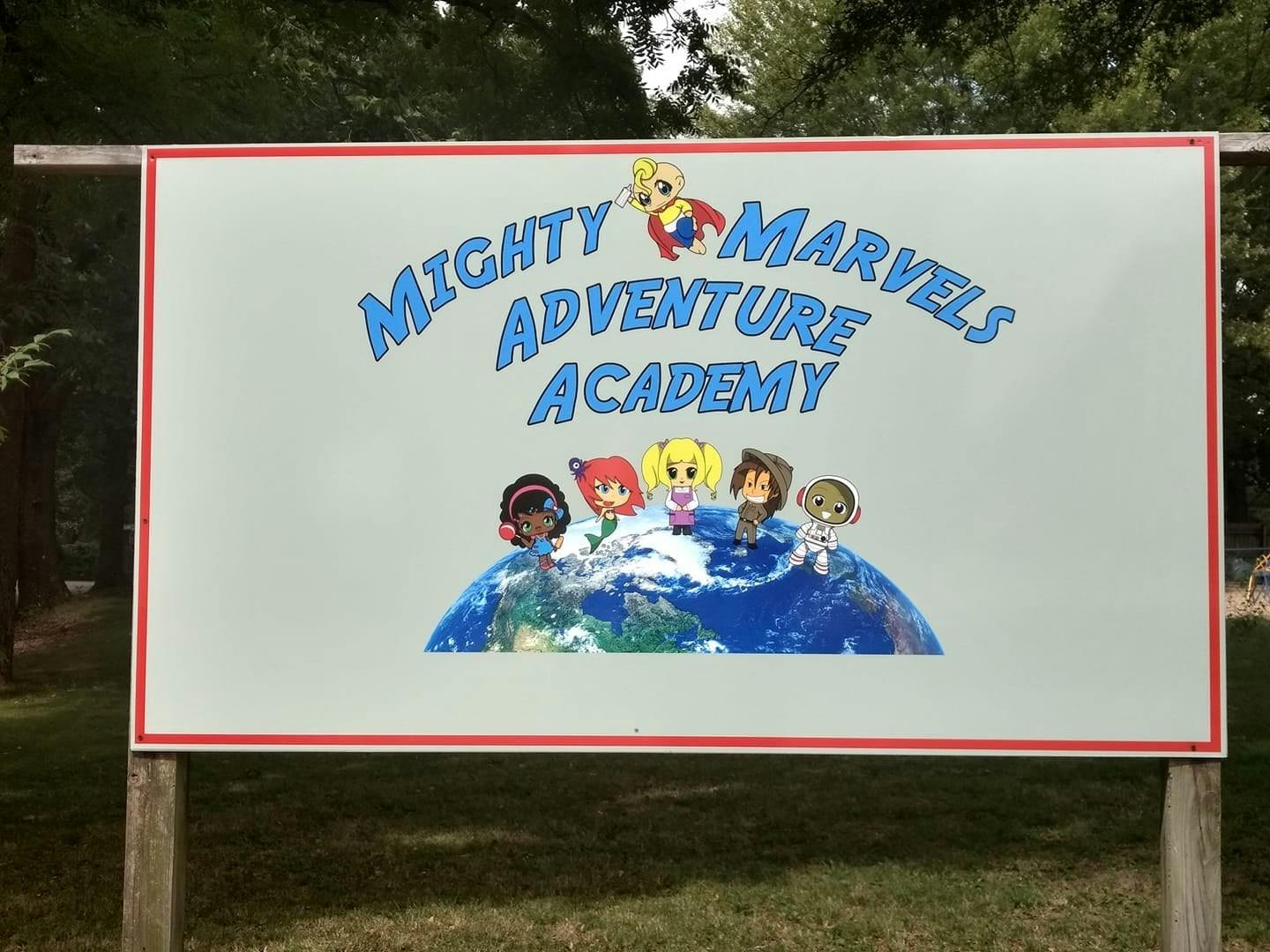 Sign for Mighty Marvels Adventure Academy with cartoon children on a globe