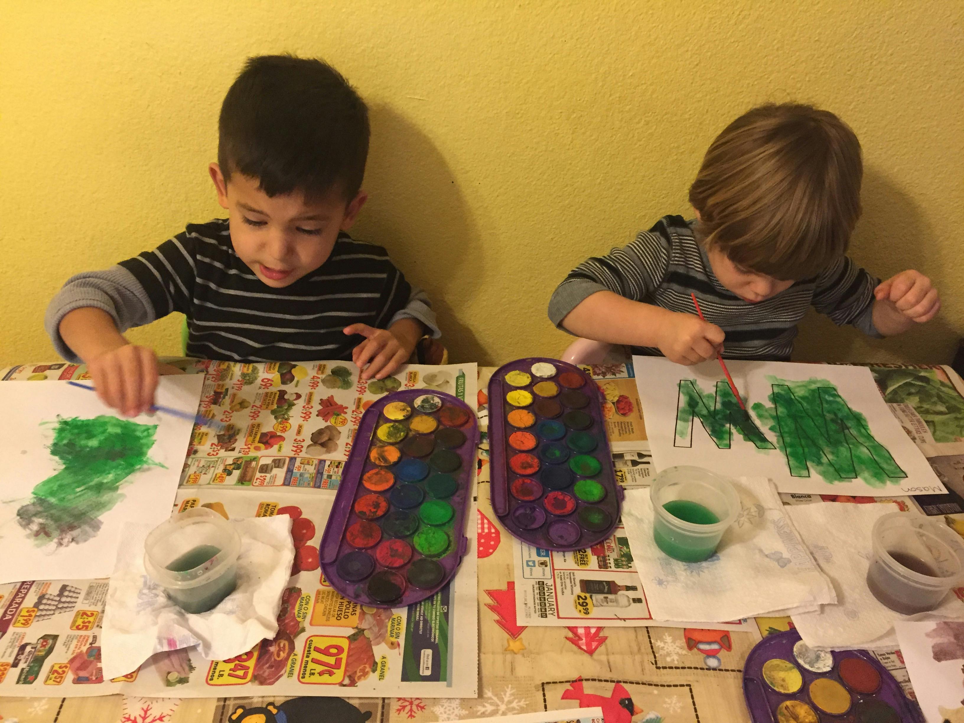 Two children painting at a table