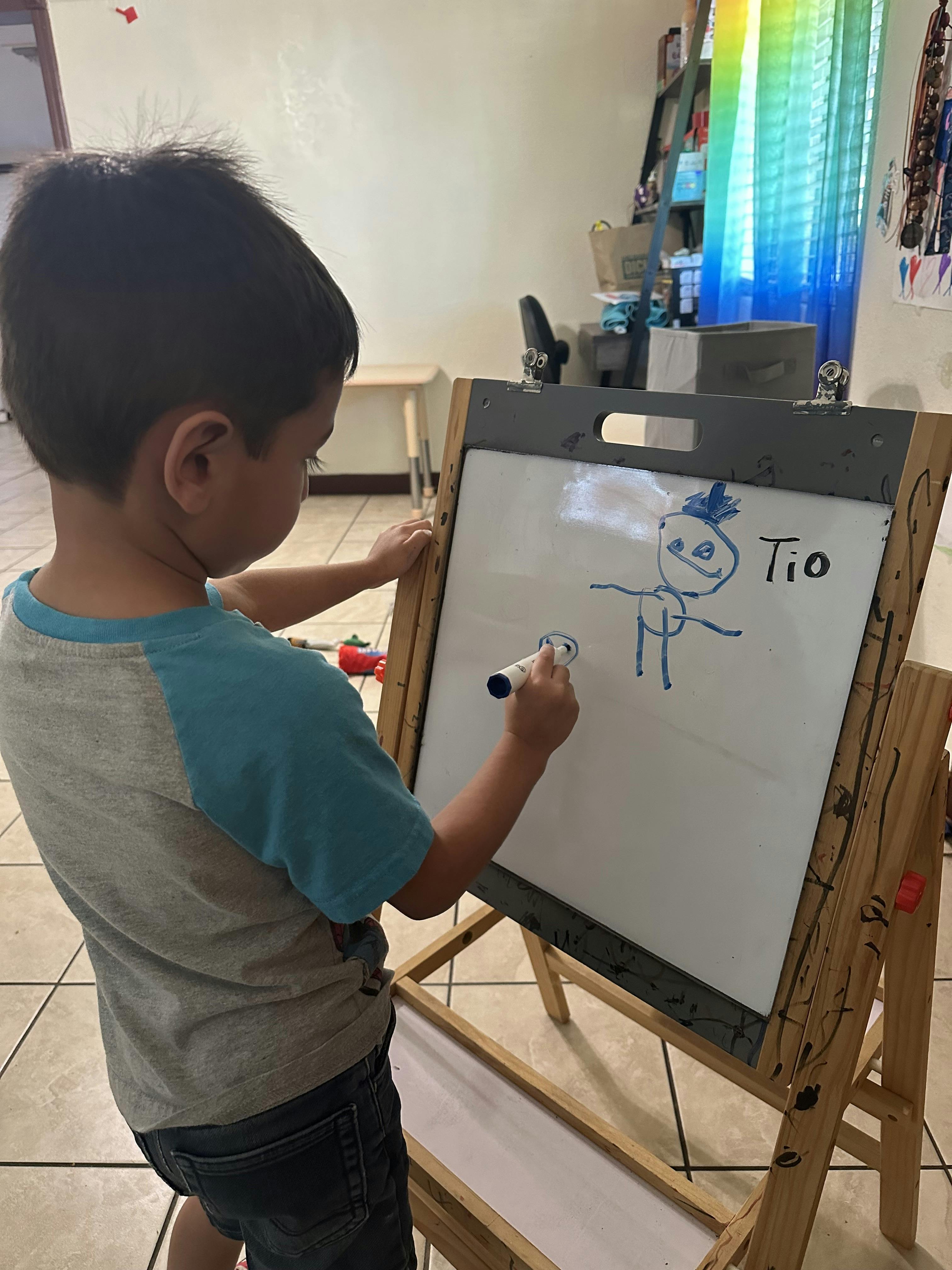 Child drawing on a whiteboard with a marker