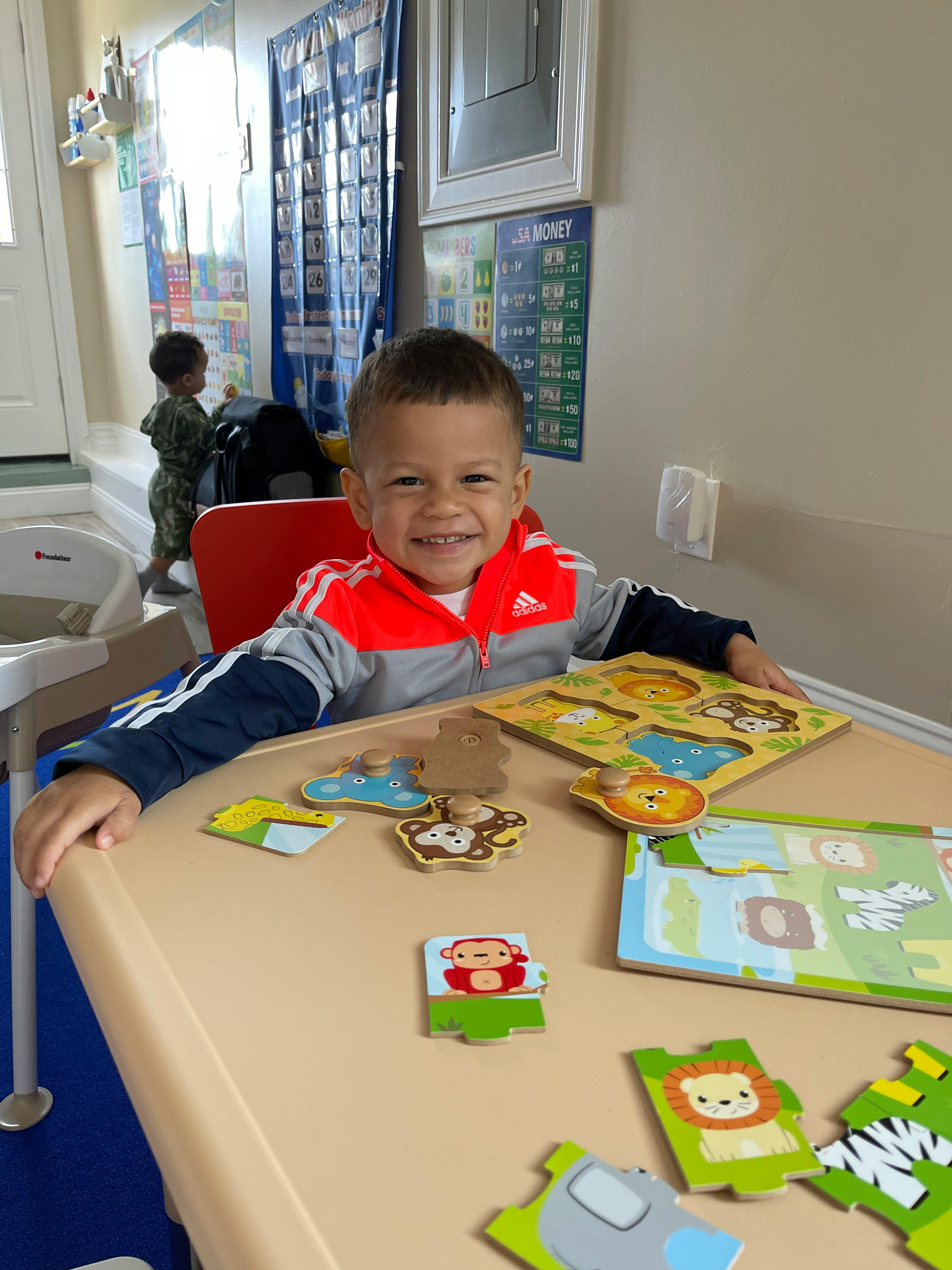 Child sitting at a table with puzzle pieces