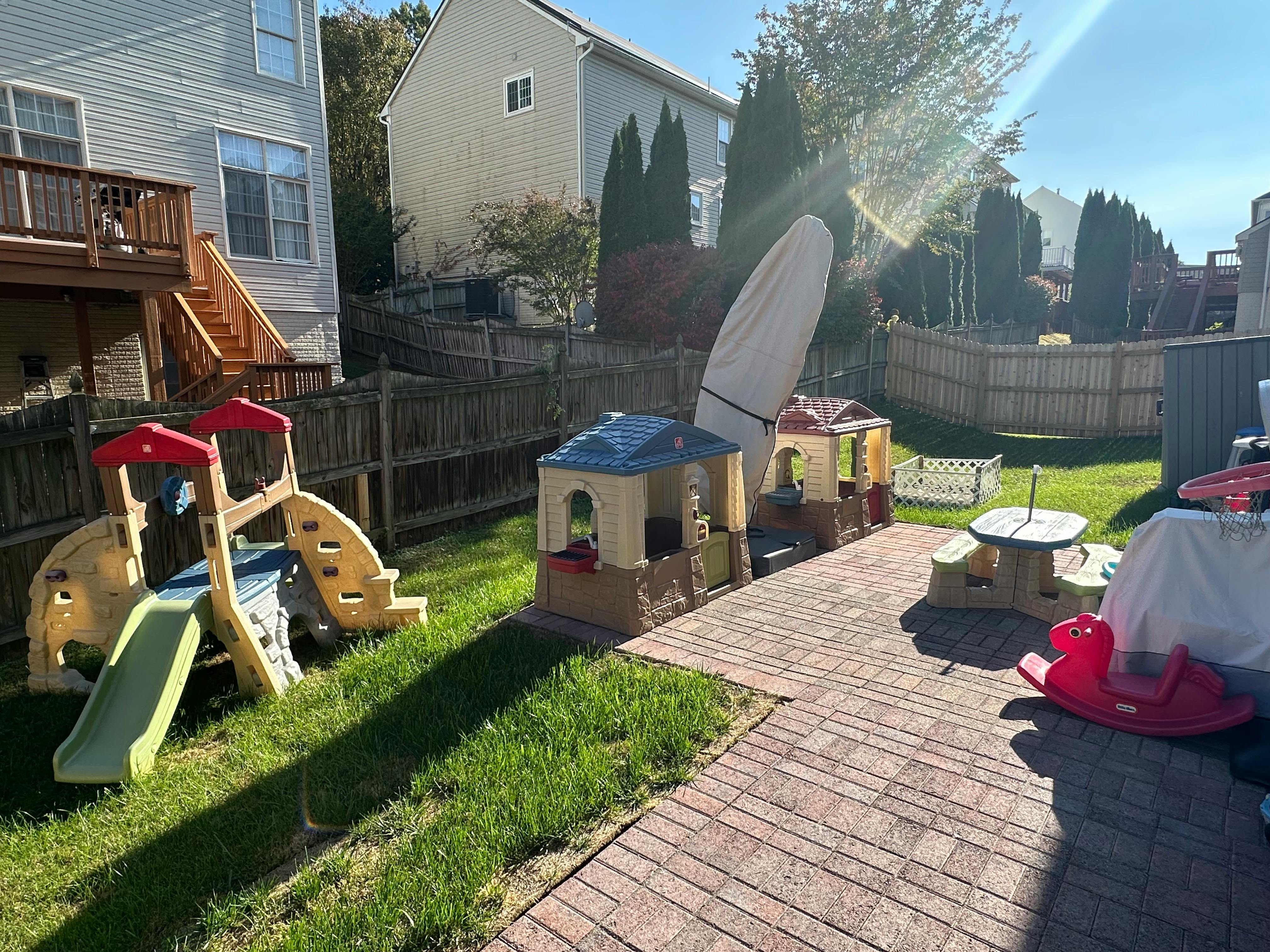 Backyard with a children's slide, playhouses, and a picnic table