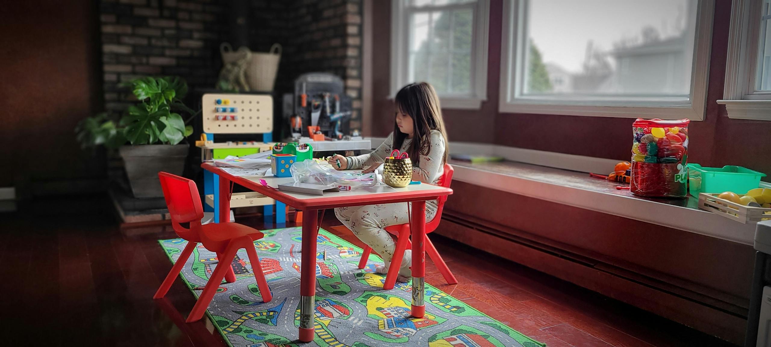 Child sitting at a small table with toys