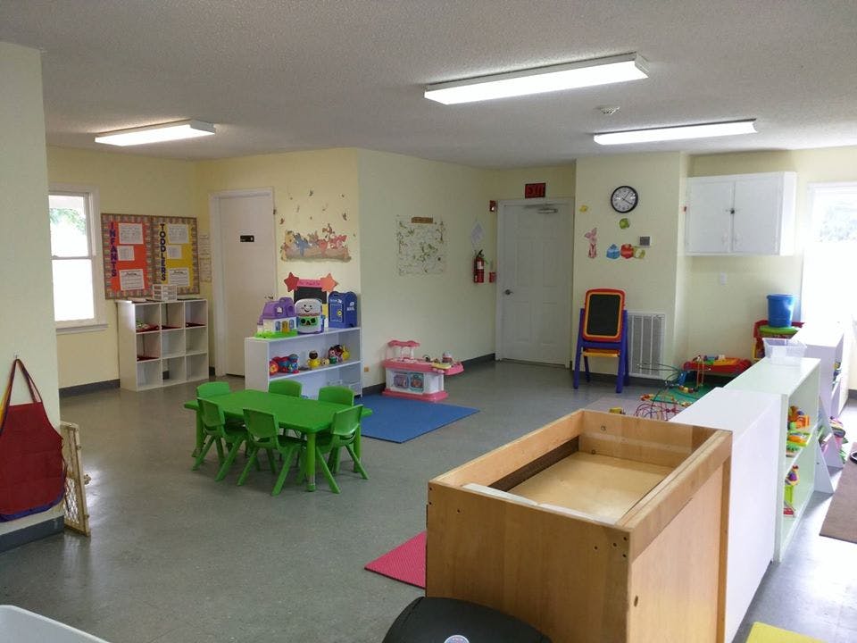 Playroom with small green table and chairs, toys, and shelves