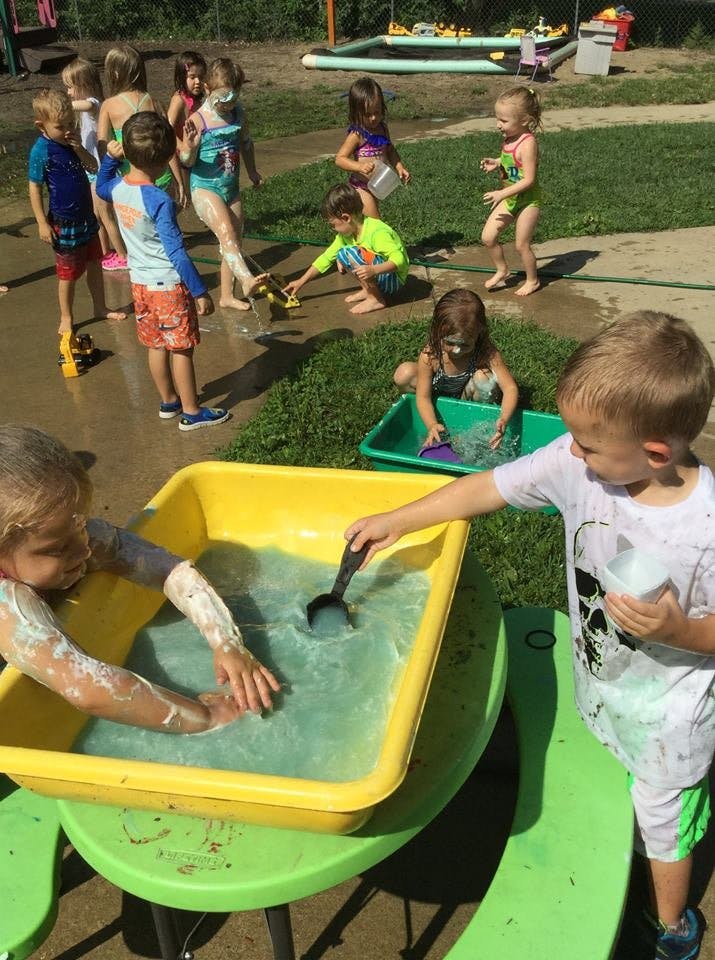 Children playing with water in outdoor tubs