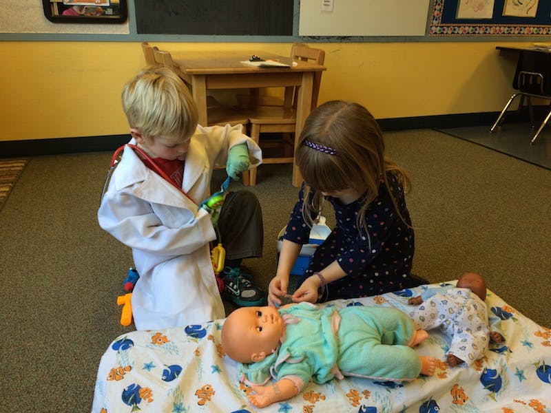 Two children playing with baby dolls