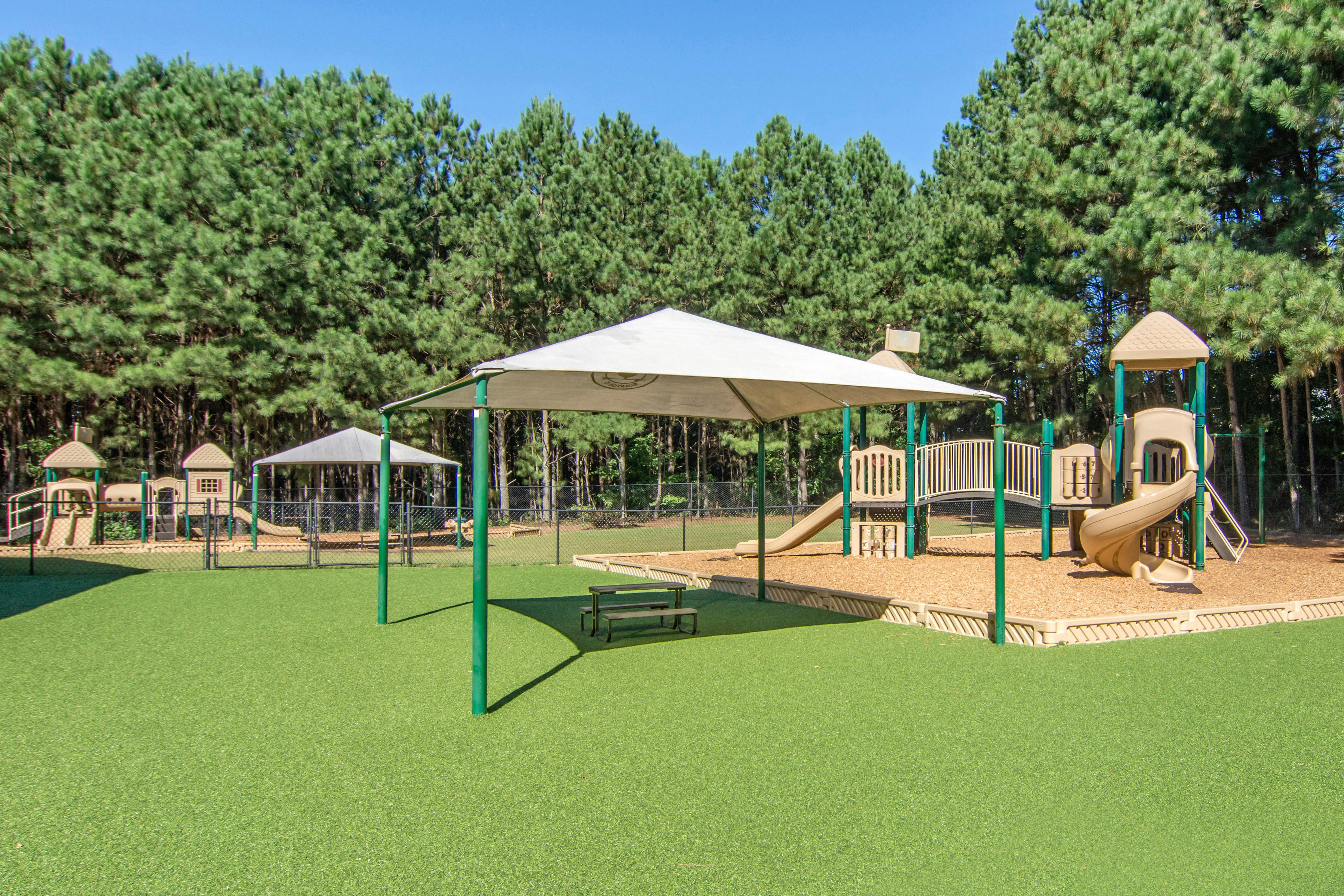 Playground with swings, slides, covered areas, and a picnic table