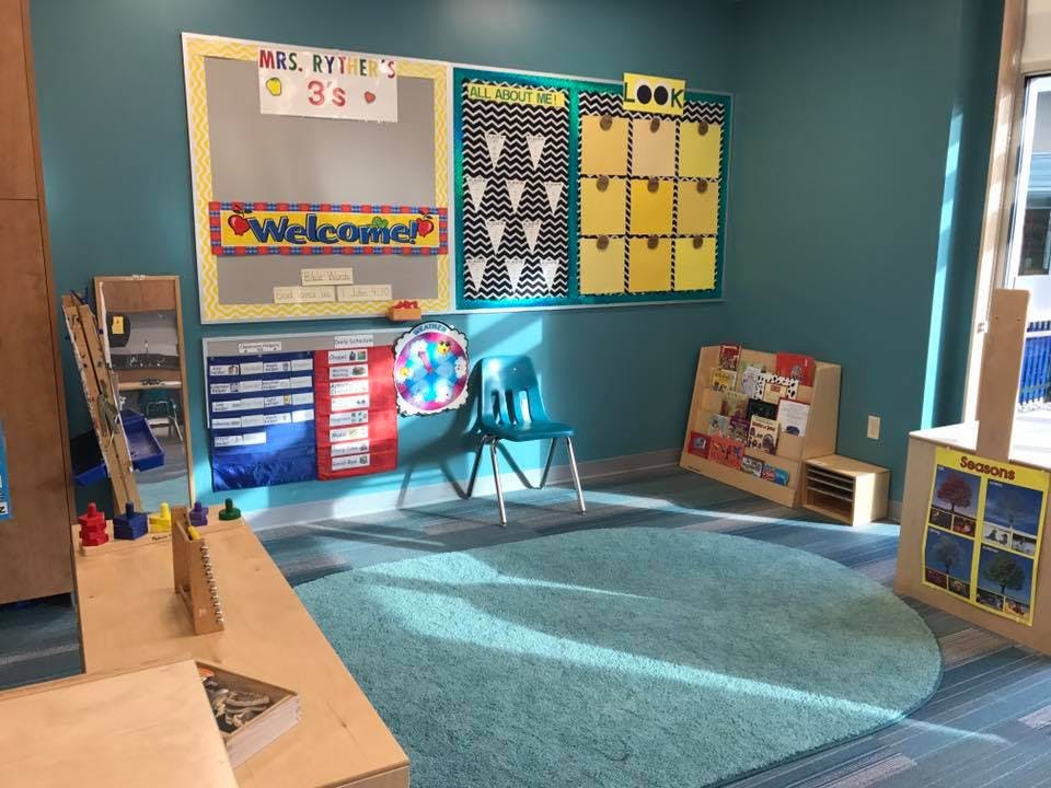 Empty classroom with a teal rug and bulletin boards