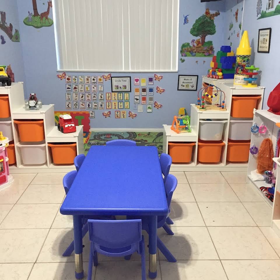 Playroom with a blue table and chairs, storage bins, and wall decorations