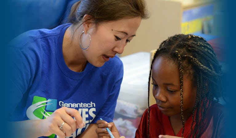 Person in blue shirt helping a child