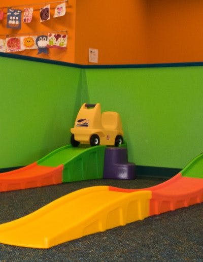 Yellow toy car on a green and orange play ramp
