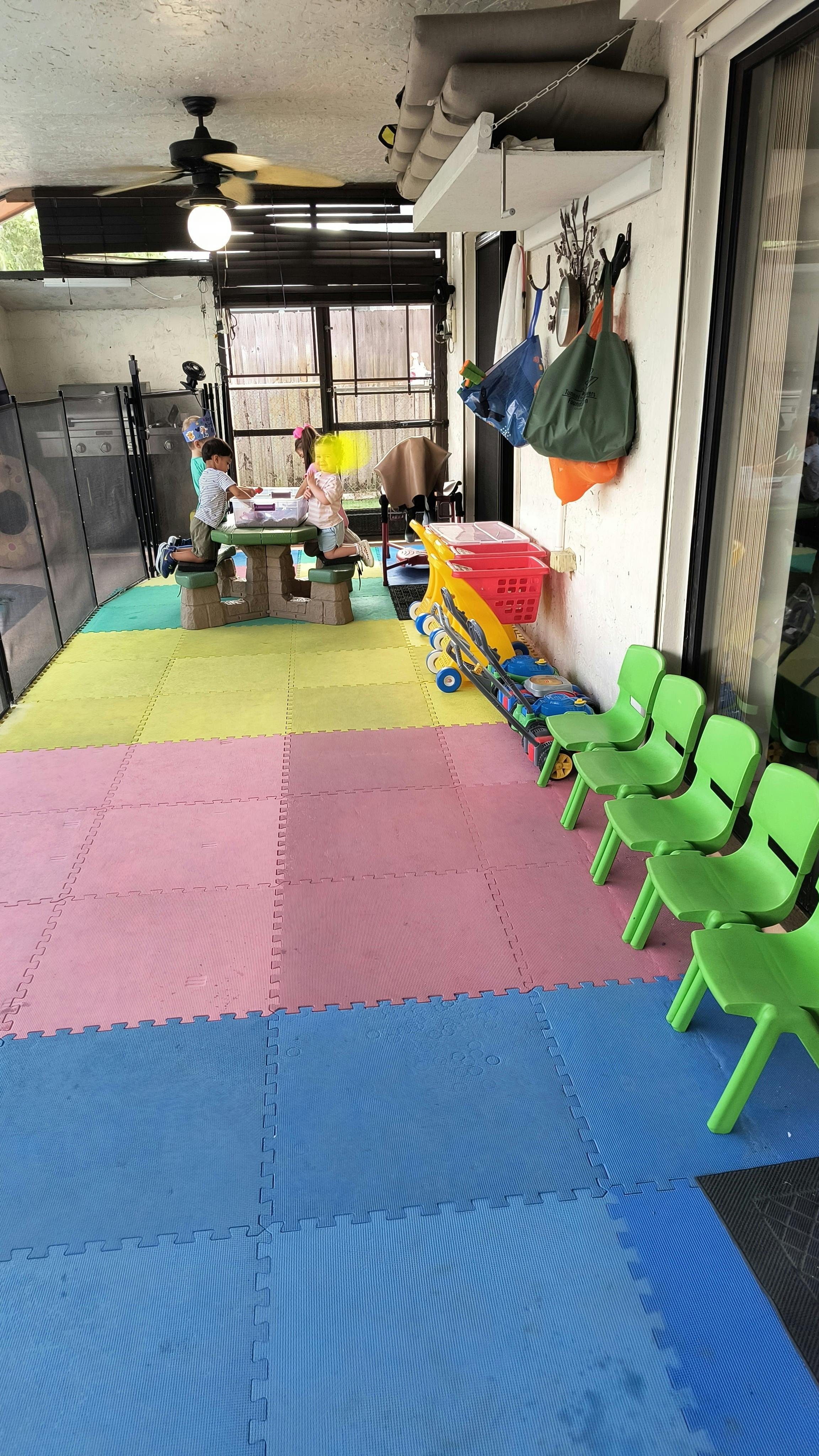 Children playing at a small table on a colorful foam mat floor