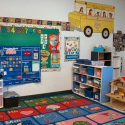 Classroom with colorful rug, bulletin boards, and shelves