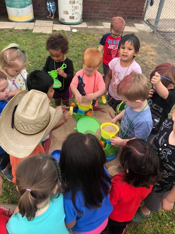 Children playing with sand toys in a sandbox