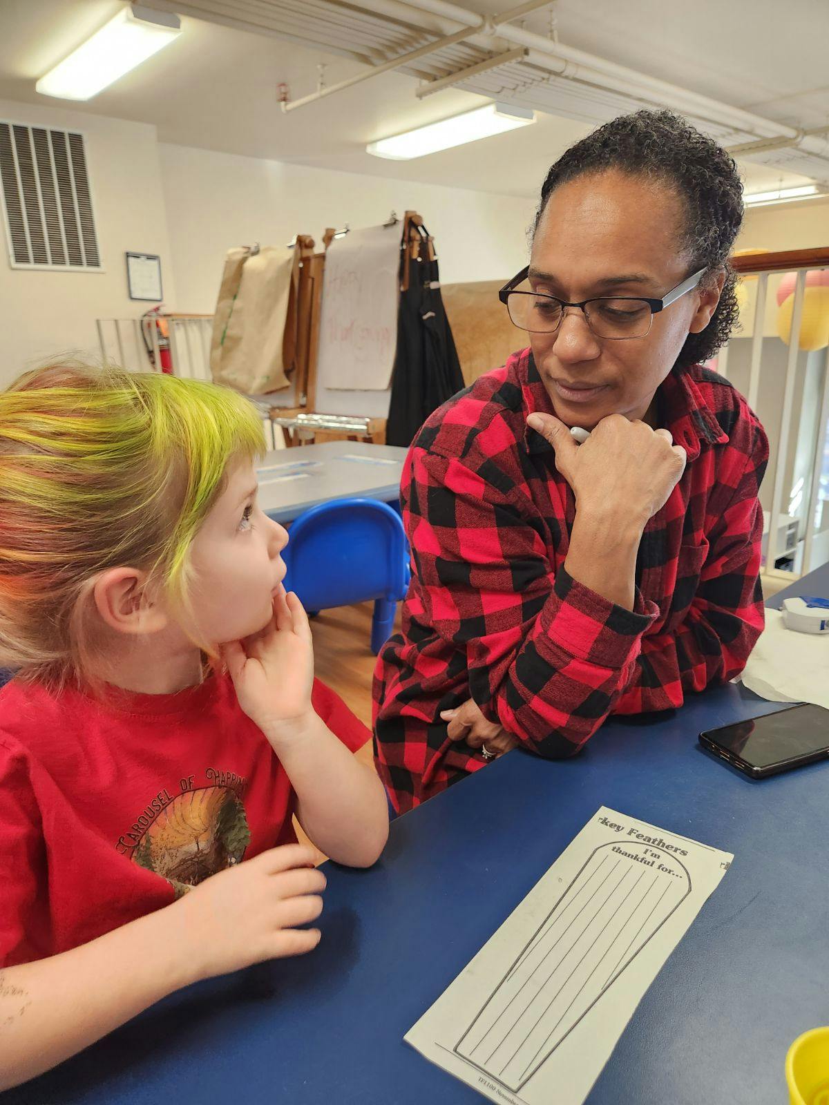 Adult and child looking at each other across a table