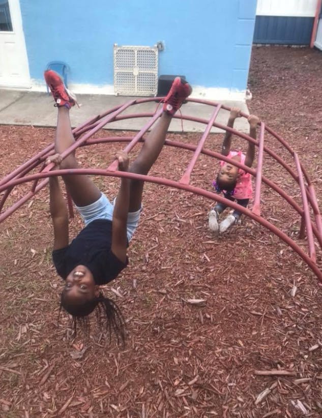 Two children playing on a red climbing dome