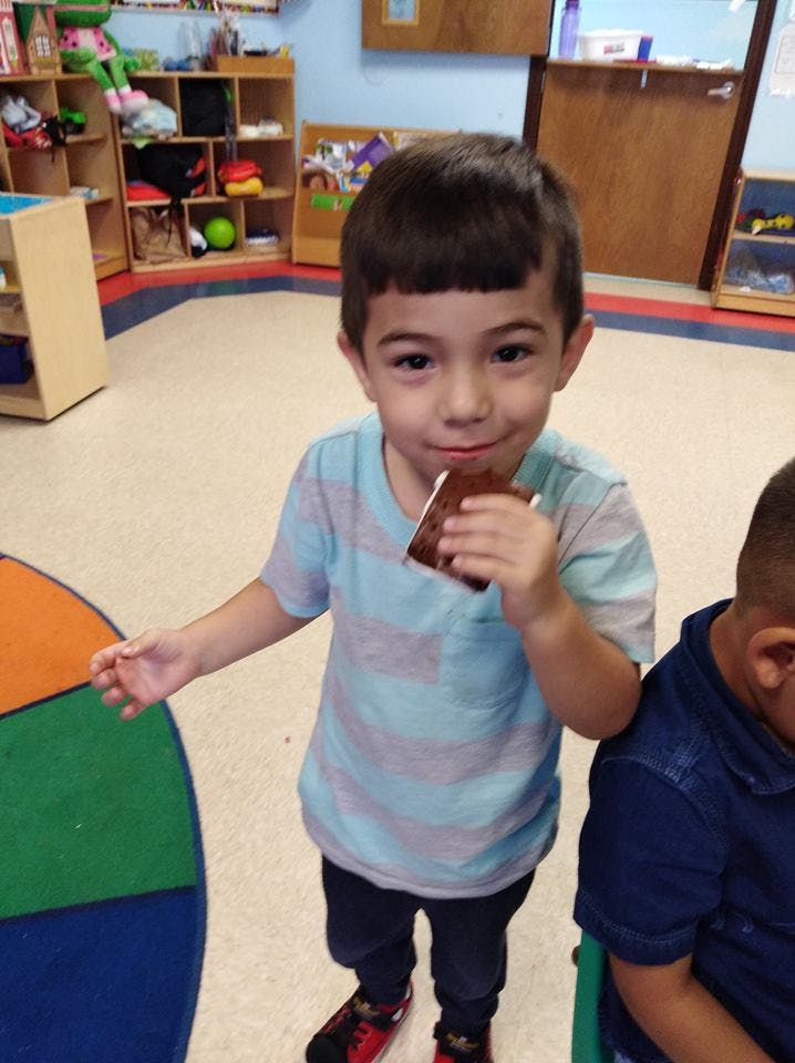 Child holding a chocolate bar in a classroom