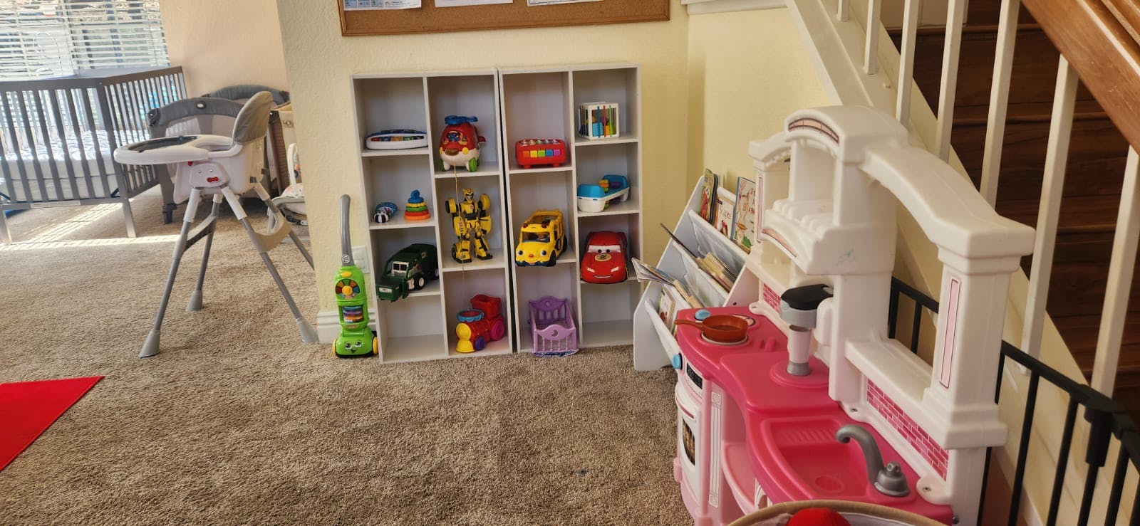 Playroom with toy kitchen, shelves of toys, and high chair
