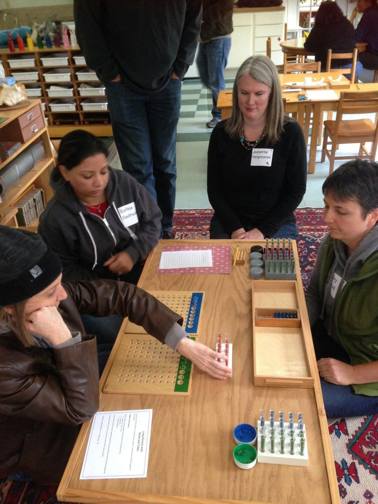 People gathered around a table with educational materials