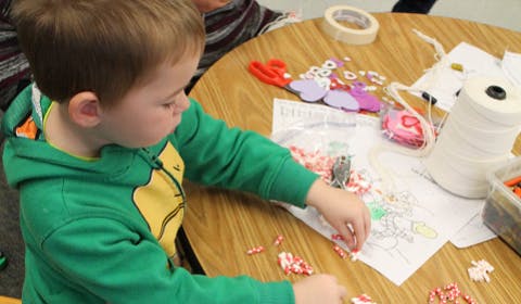 Child doing a craft at a table