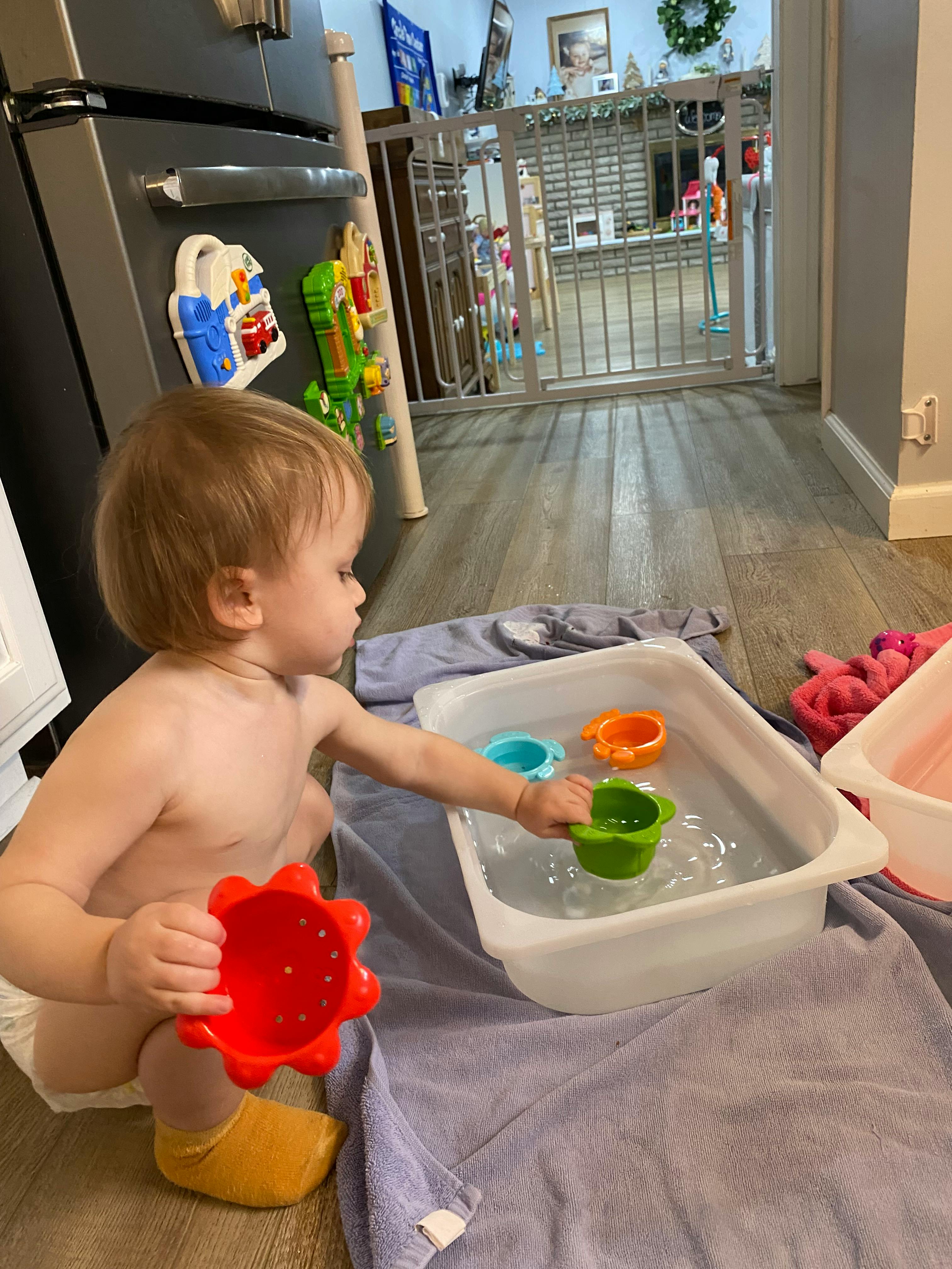 Child playing with water and toys in a tub