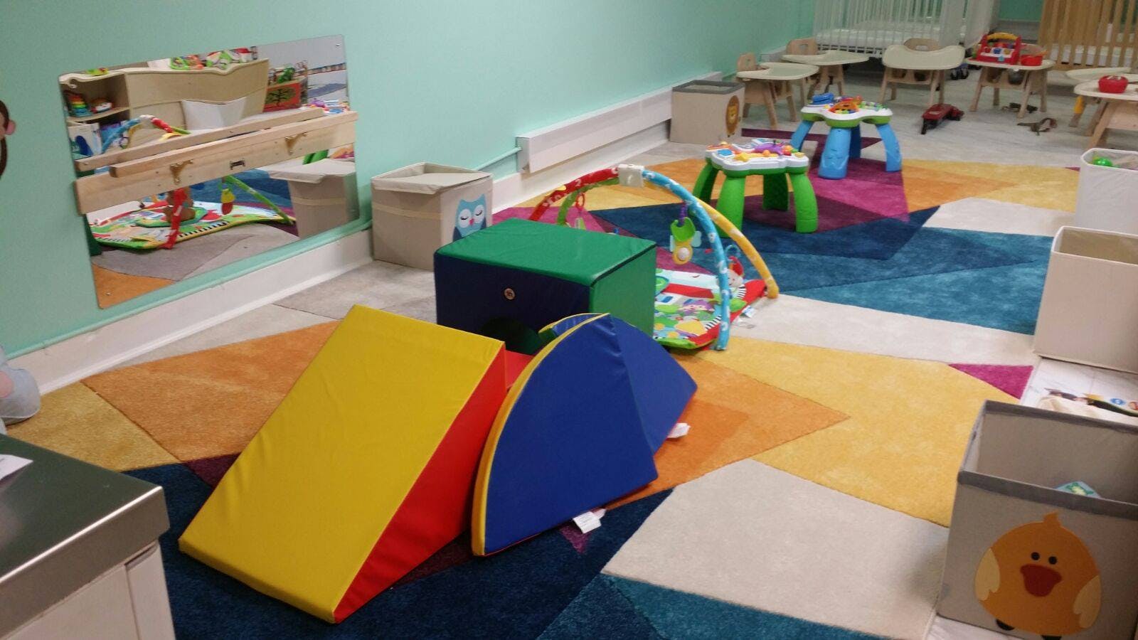 Playroom with colorful rug and soft play equipment