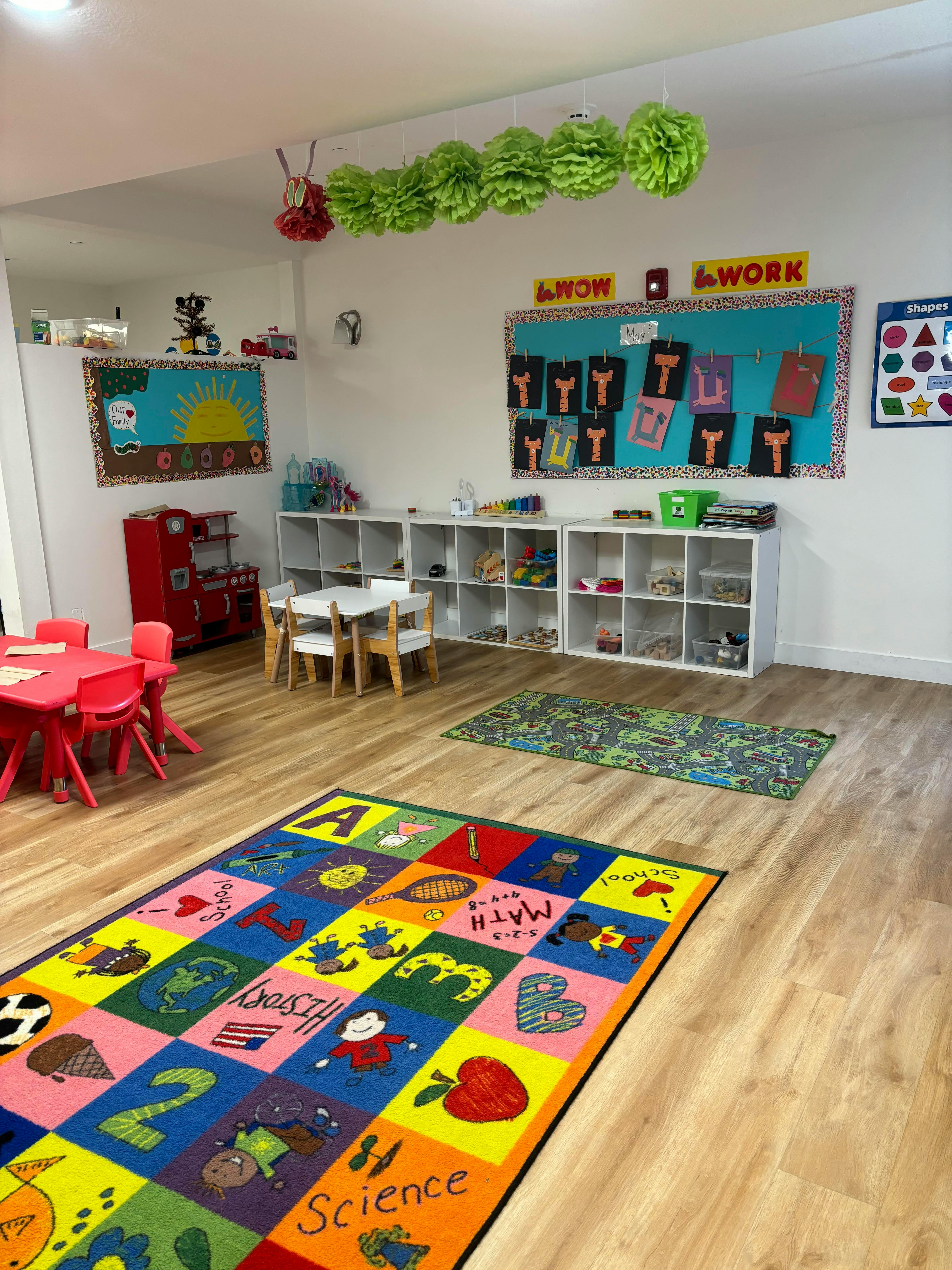 Classroom with colorful rug, small tables and chairs, and storage shelves