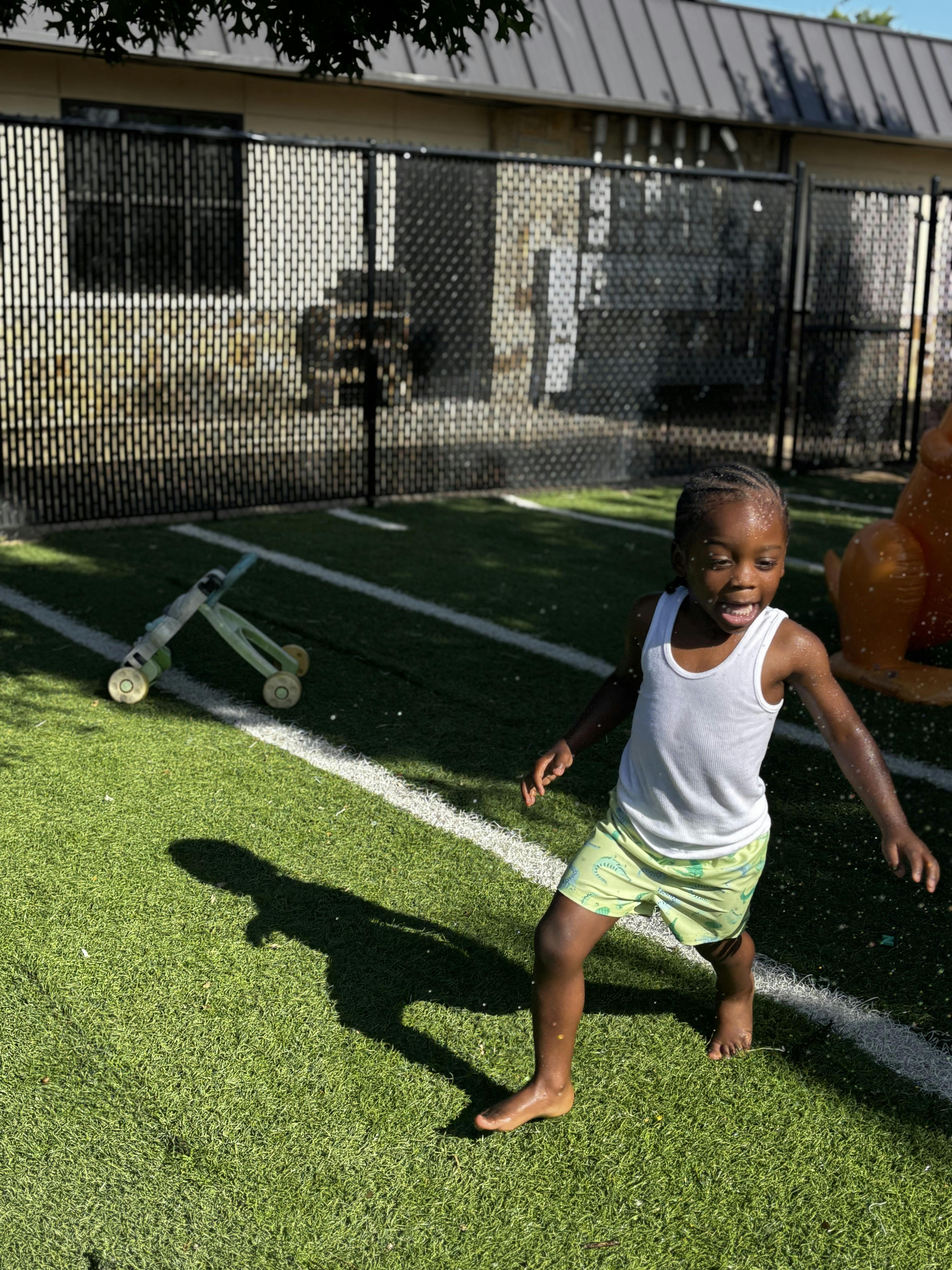 Child running barefoot on artificial grass