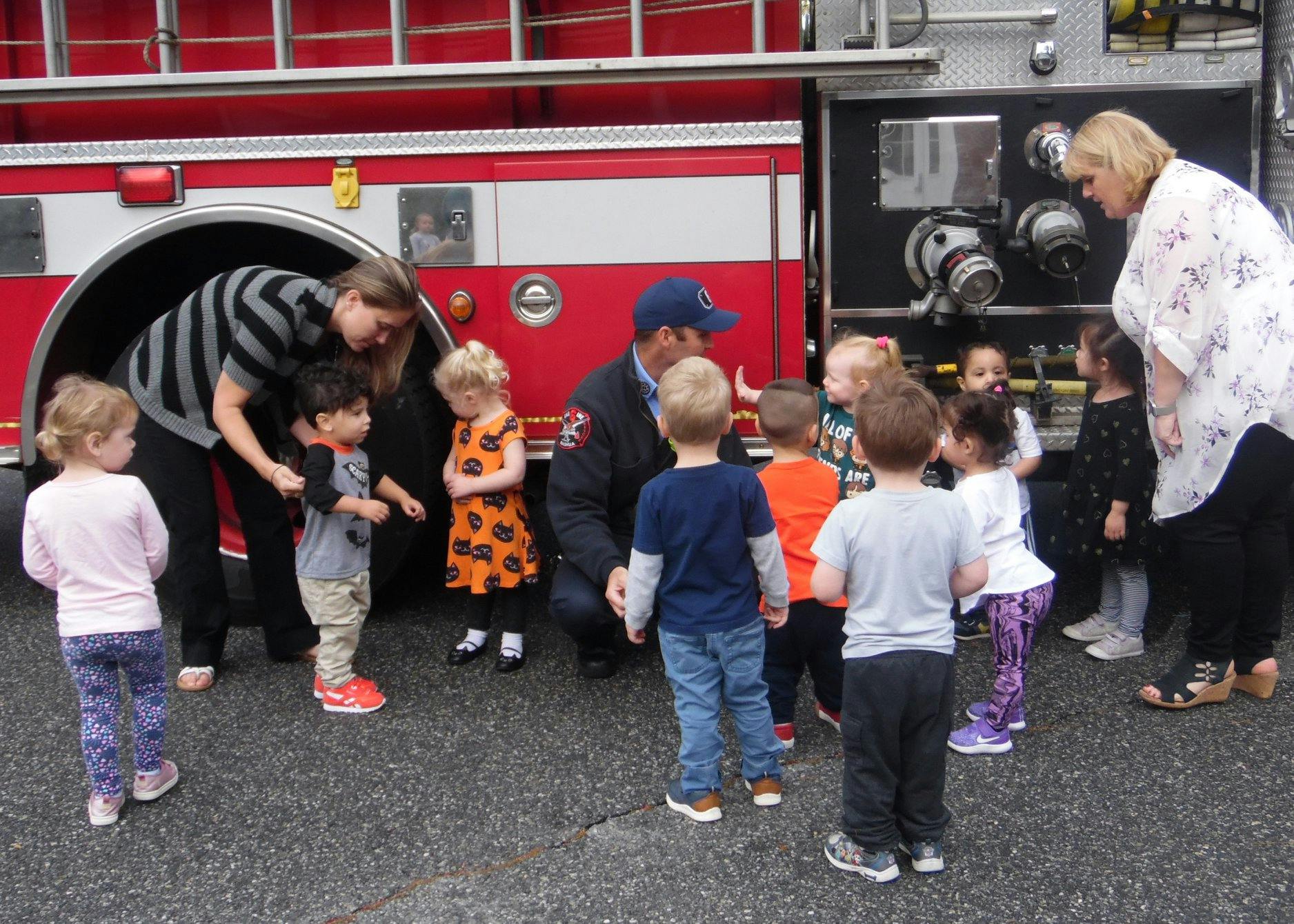 Adults and children gathered around a fire truck
