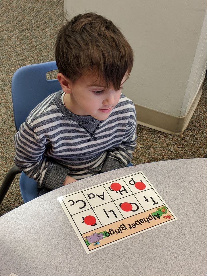 Child playing Alphabet Bingo at a table