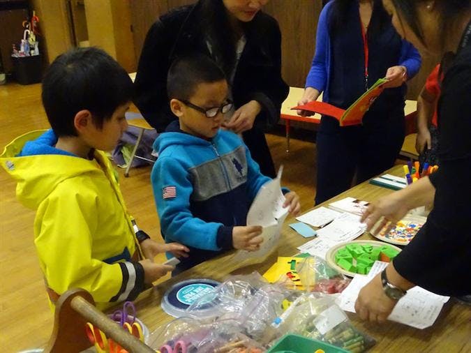 Two children at a table with craft supplies