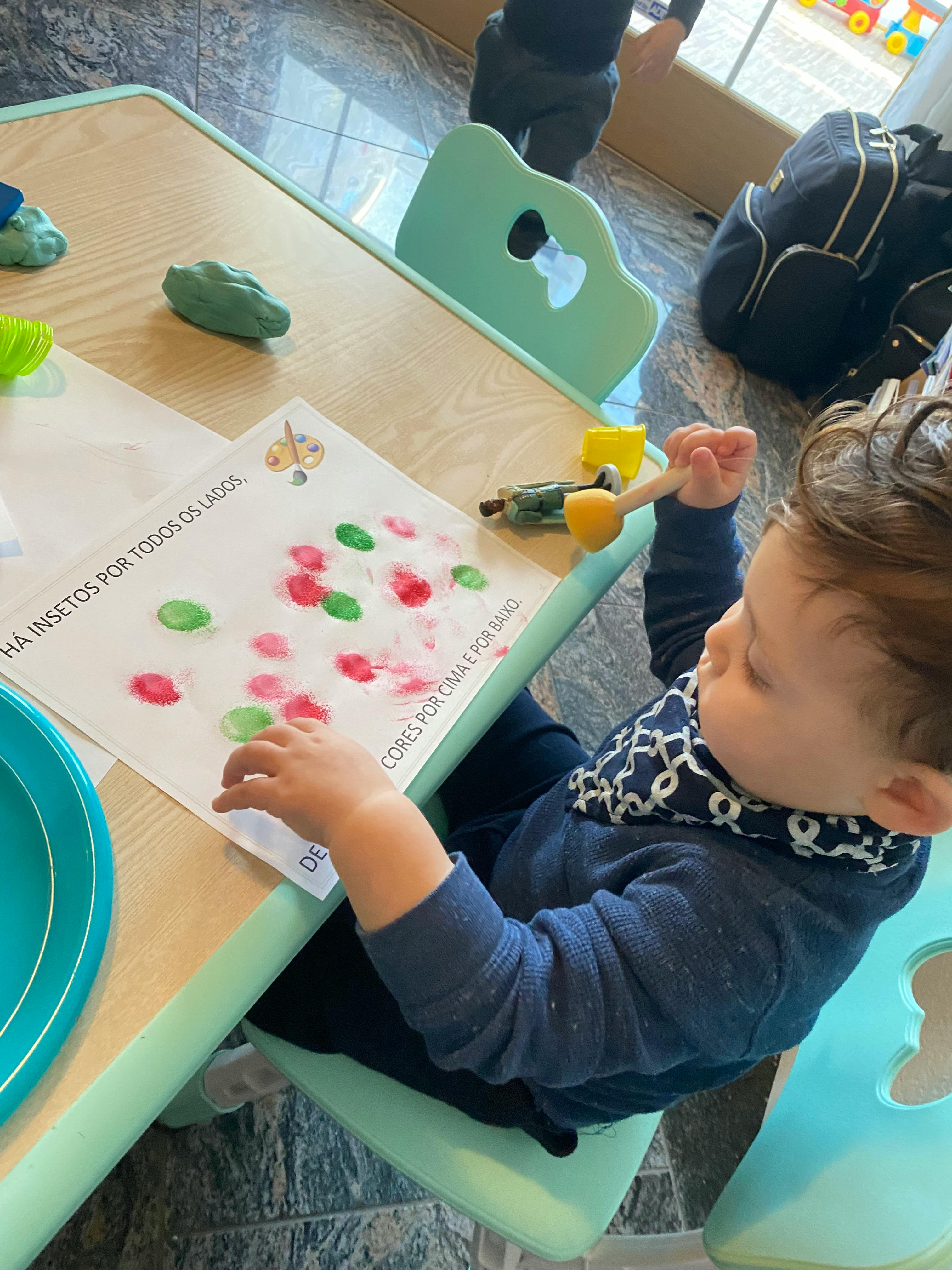 Child painting on paper at a table