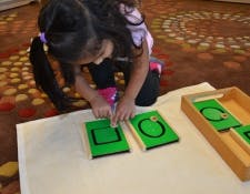Child playing with green shape puzzles
