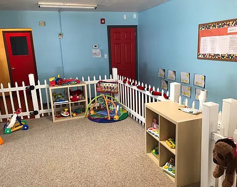 Playroom with white picket fence, toys, and red doors