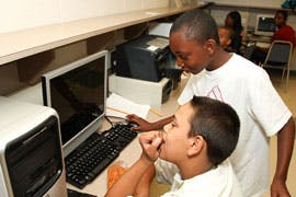 Two children looking at a computer screen