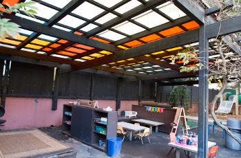 Outdoor play area with a translucent roof and small tables
