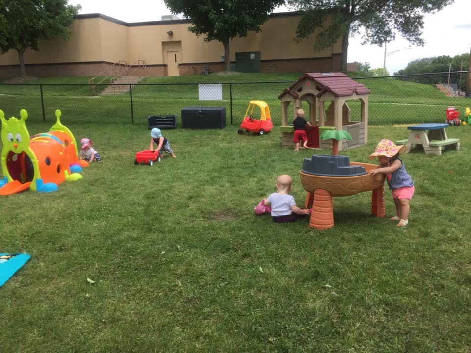 Children playing with toys on a grassy playground