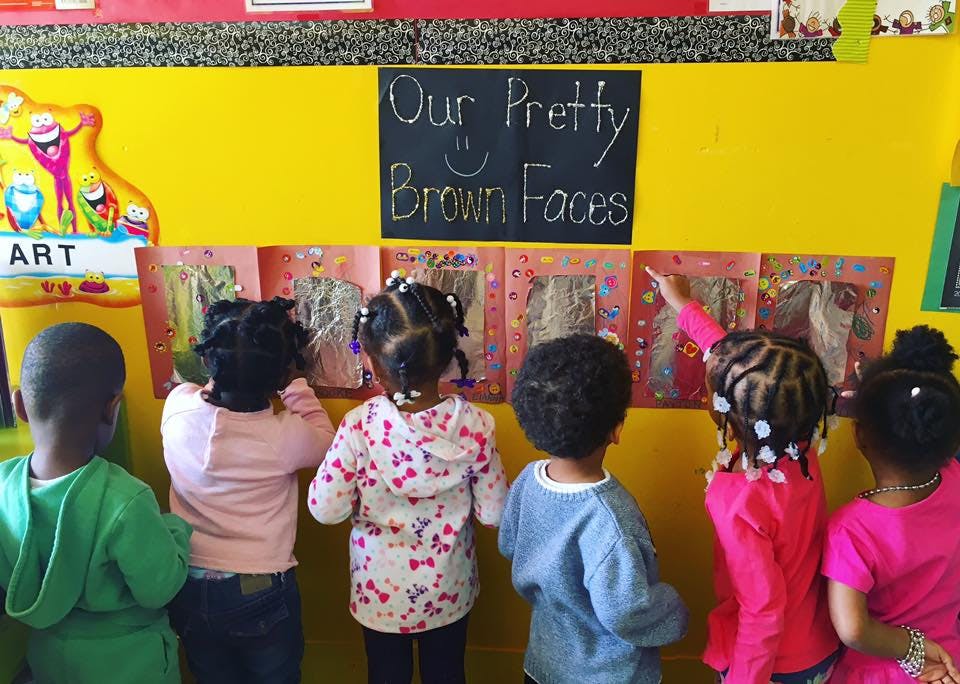 Children looking at artwork on a wall in a classroom