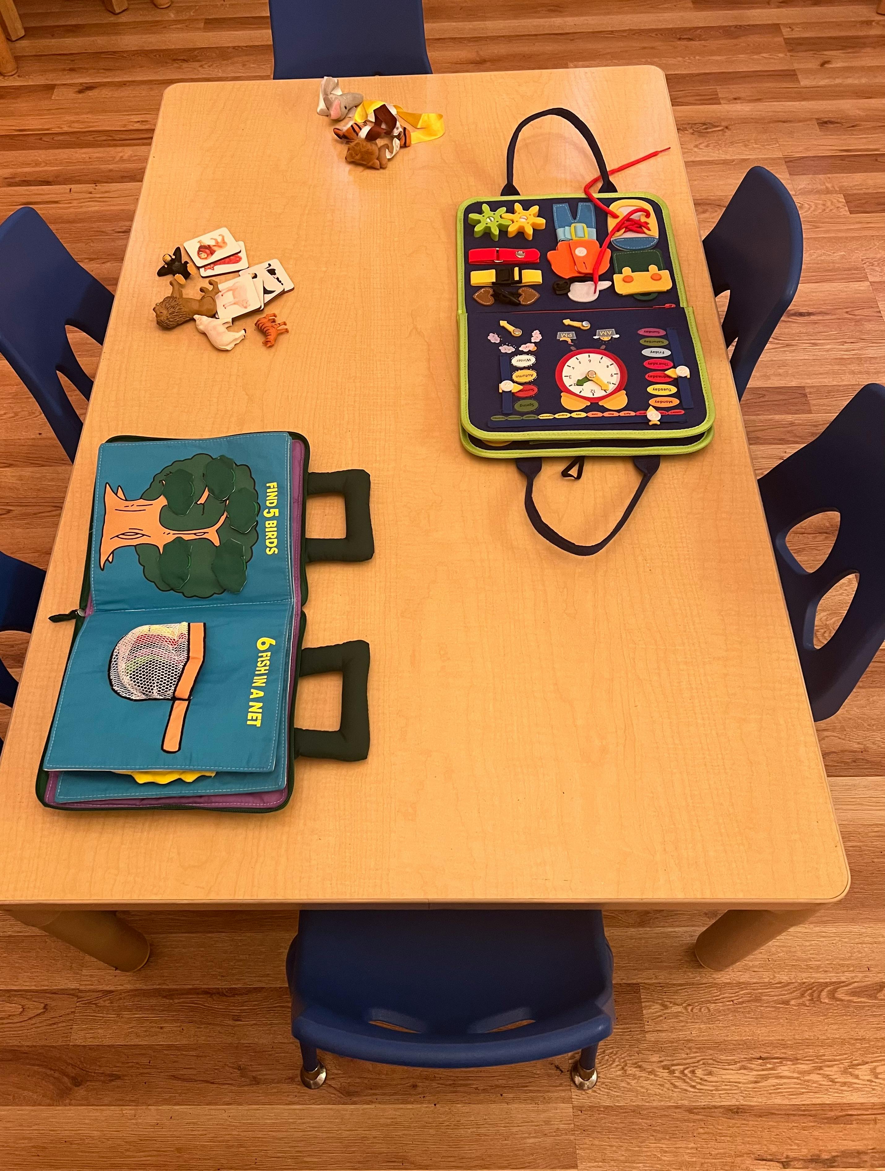 Activity books and small toys on a light wooden table