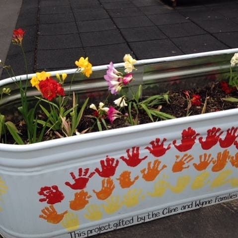 Planter box with flowers and handprints on the side