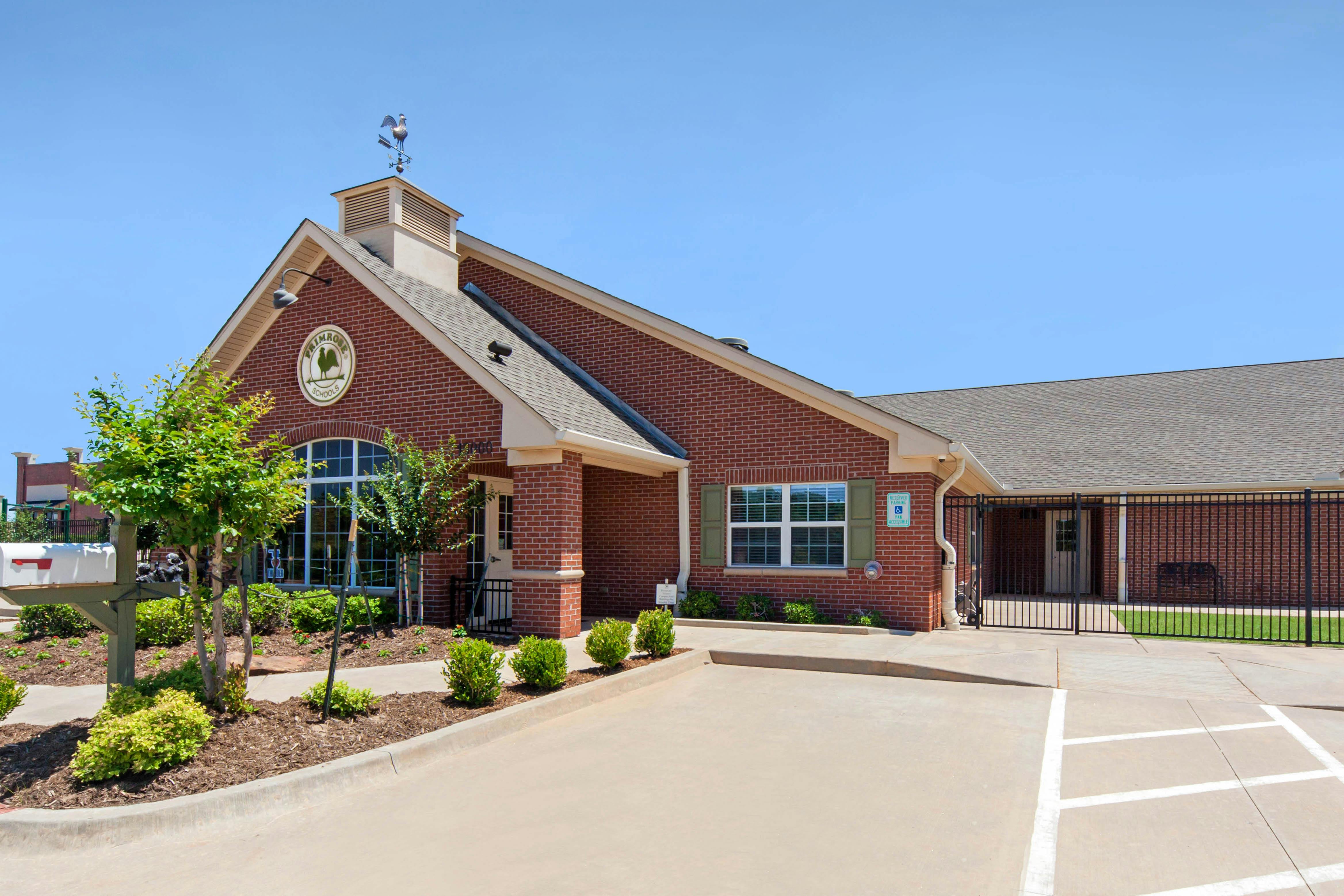 Brick building with a prominent sign for "Primrose Schools" and a weather vane