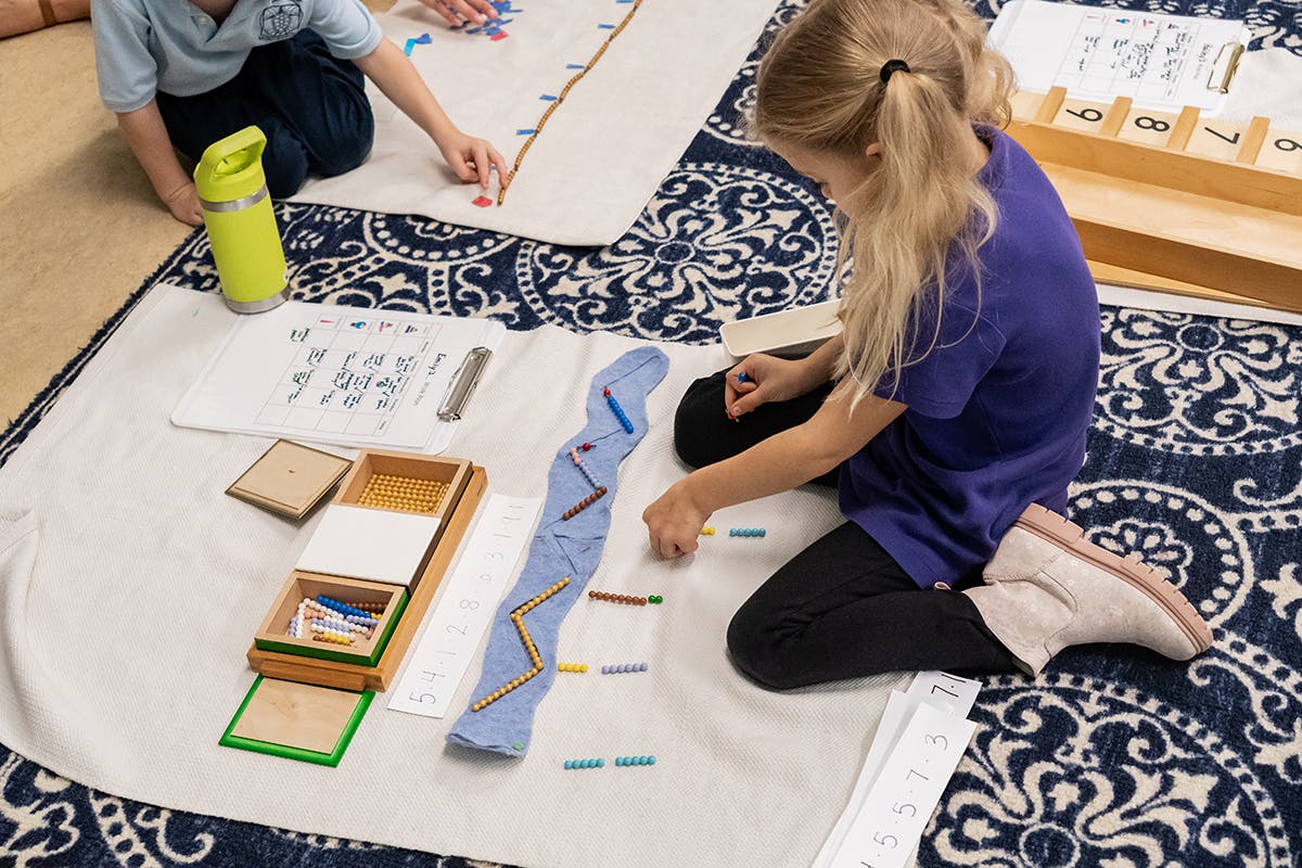 Two children working on floor with learning materials